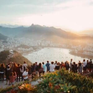 group of people standing facing lake view